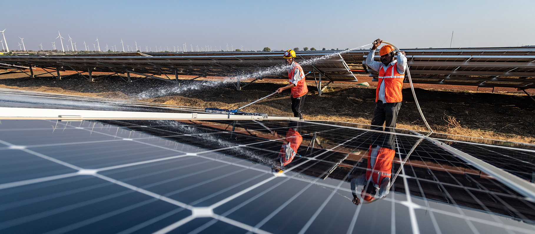 cleaners cleaning solar panels with water